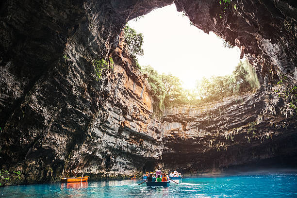 Kefalonia, Greece - September 11, 2014: Tourists visiting Melissani Cave (Kefalonia Island, Greece). Boats full of tourists on a turqouise lake inside of a cave.