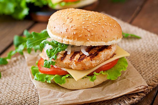 Sandwich with chicken burger, tomatoes, cheese and lettuce stock photo
