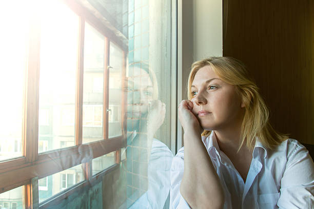 istock The woman lost in thought looking out the window. 478490630