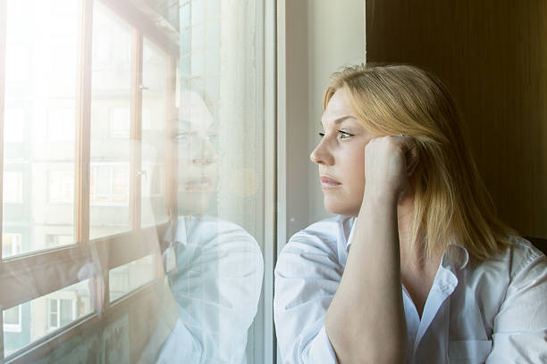 istock The woman lost in thought looking out the window. 478490678