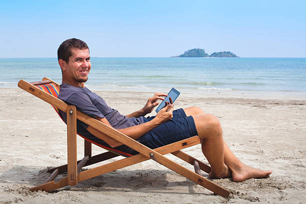 istock business man with tablet on the beach 478490806