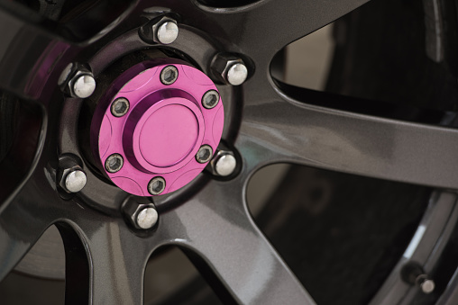 close up of chrome rim wheel and pink hub center wheel