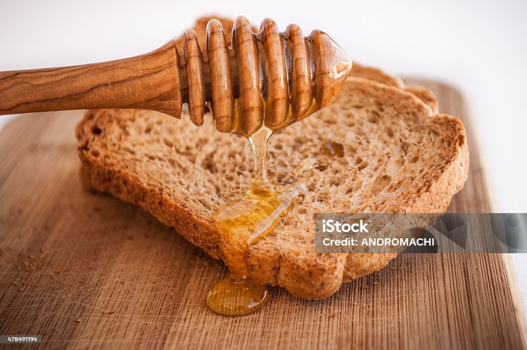 toasted bread with honey and honey dipper isolated in white 2015 Stock Photo