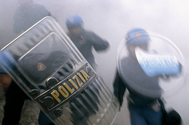 Upload Police Rome, Italy - April 14, 2008: Agents of the mobile unit of the State Police in action during a protest in the streets of the capital. Charging is accompanied by an intensive use of tear gas to disperse the crowd. riot tear gas stock pictures, royalty-free photos & images