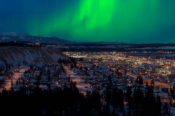 Northern Lights over Downtown Whitehorse Strong northern lights (Aurora borealis) substorm on night sky over downtown Whitehorse, capital of the Yukon Territory, Canada, in winter. north photos stock pictures, royalty-free photos & images