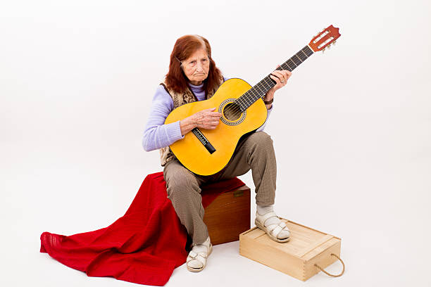 istock Funny elderly lady playing acoustic guitar 478493010