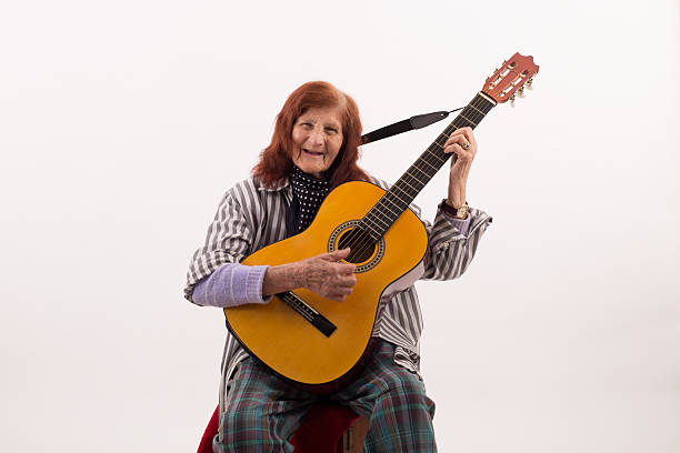 istock Funny elderly lady playing acoustic guitar 478493012