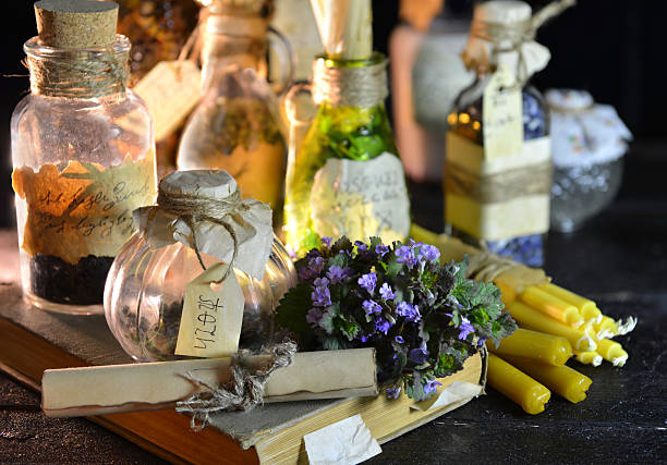 Magic still life with witch bottles, herbs and candles Magic still life with witch bottles and healing herbs. Halloween or homeopathic image. Signs on labels are not foreign text, these letters are imaginary, fictional symbols. potion bottle retro revival old fashioned stock pictures, royalty-free photos & images