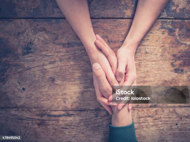 Man And Woman Holding Hands At A Table Stock Photo - Download Image Now - Consoling, Love - Emotion, Touching