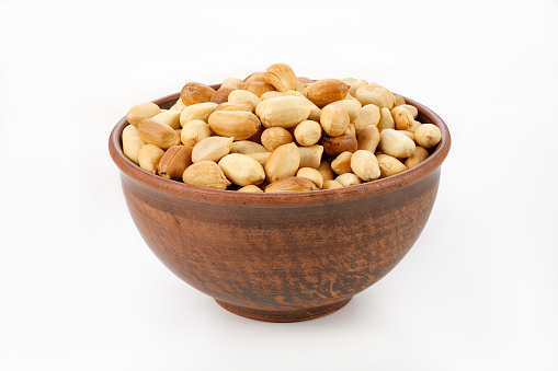 roasted peanuts in a bowl on a white background isolated