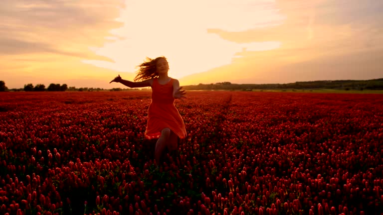 SLO MO Joyful girl running in field of crimson clover