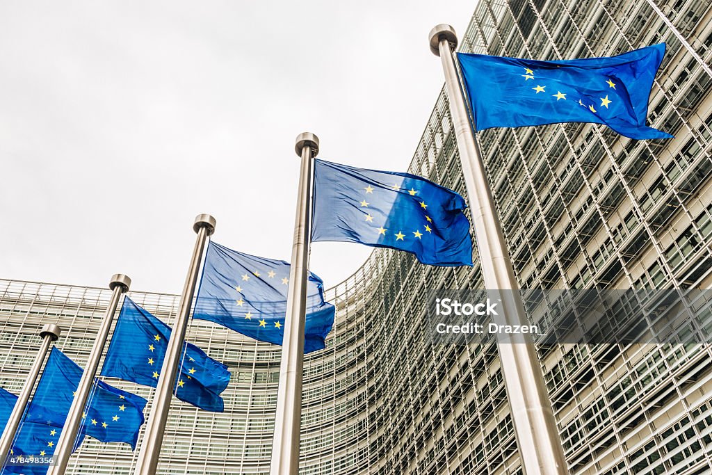 EU flags near EU headquarters Berlaymont European Commission building Blue EU flags with its stars in Brussels in front of European Commission and Parliament, image taken with Nikon D800 and 24-70 professional lens in RAW file and developed in XXXL size European Parliament Stock Photo
