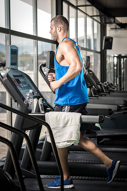 istock Young man running at treadmill in gym 478498946