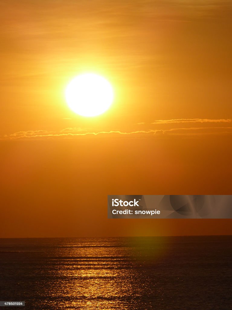 sunset at the ocean A great ball of orange fire is in the sky. 2015 Stock Photo