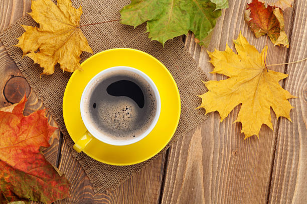 istock Autumn leaves and coffee cup over wood background 478502444
