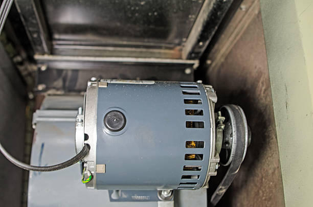 The chamber in an older home furnace showing the motor and blower fan.