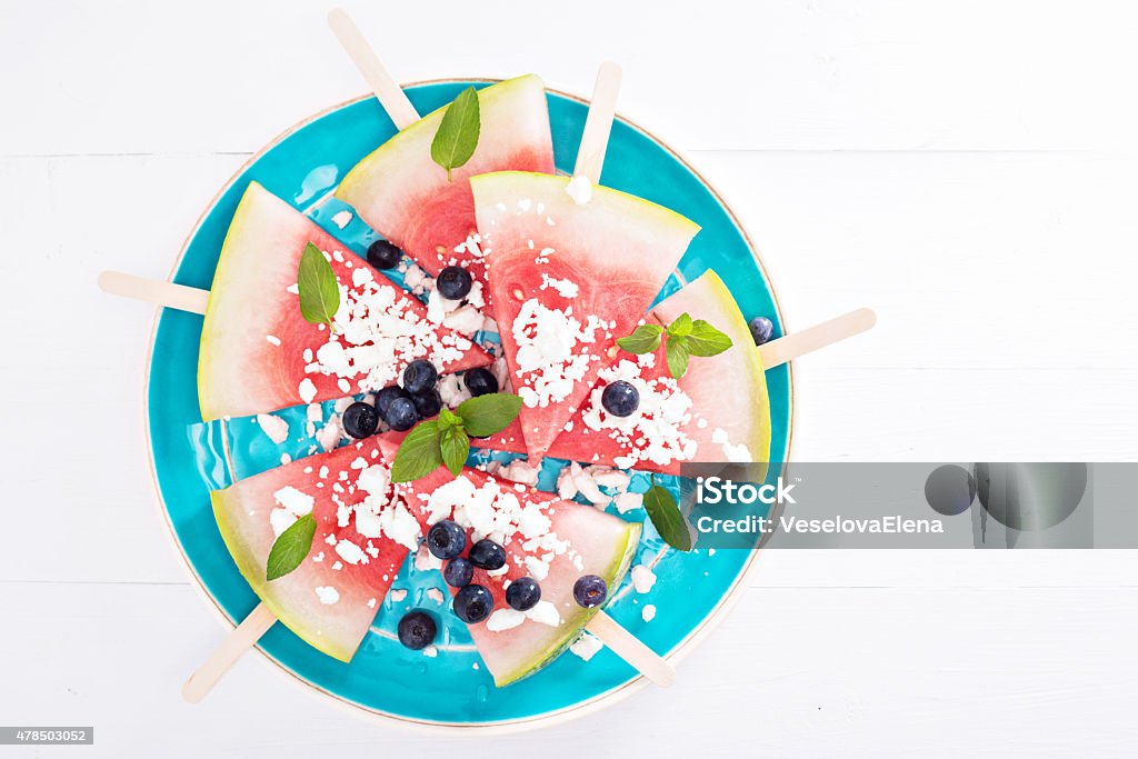 Fresh watermelon popsicles with blueberries Fresh watermelon popsicles with blueberries and cheese cut on ice 2015 Stock Photo
