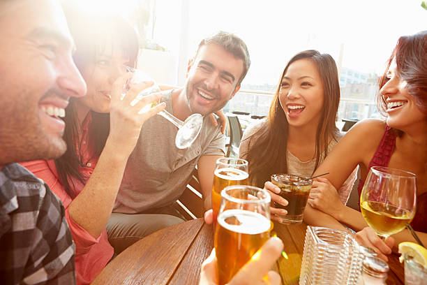 gruppo di amici, godersi un drink al bar sulla terrazza all'aperto - friendship drinking beer group of people foto e immagini stock