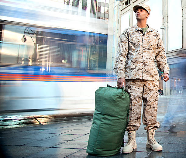 US Marine Soldier Coming Home US Marine soldier with a duffle bag in the city. The model is wearing an official US Marine corps Marpat BDU uniform. us military photos stock pictures, royalty-free photos & images