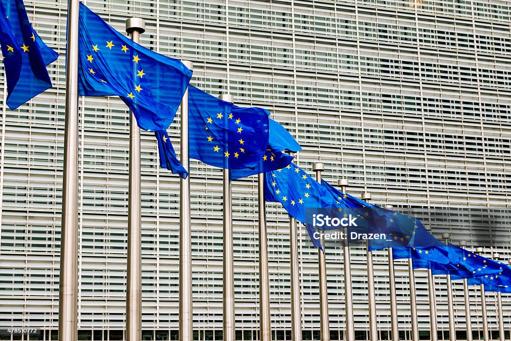 EU flags near EU headquarters Berlaymont European Commission building Blue EU flags with its stars in Brussels in front of European Commission and Parliament 2015 Stock Photo