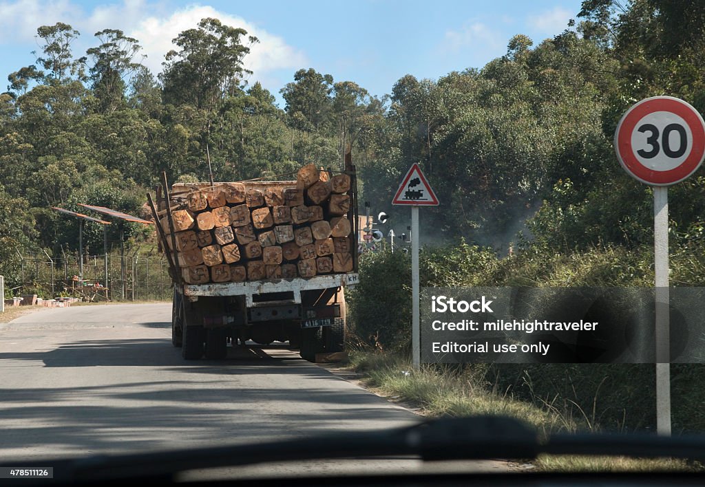Logging truck parked on Antananarivo Madagascar highway Antananarivo, Madagascar - May 12, 2015: Parked on the side of the Highway RN2, a large truck loaded with numbered logs stands in front of a 30 kilometer per hour speed limit and railroad sign in the forested mountains east of Antananarivo in the Hauts Plateau. 2015 Stock Photo