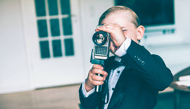 istock Little boy makes a movie with retro video camera 478513644