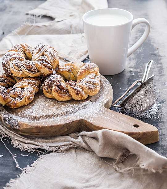 istock Cinnamon buns with sugar powder on rustic wooden board, mug 478519818