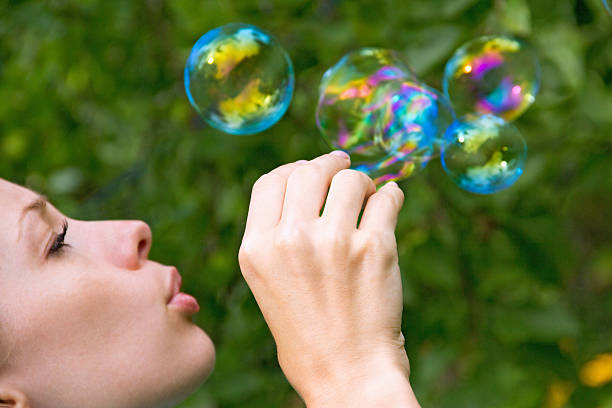 istock Cute girl blowing bubbles outdoors 478521486