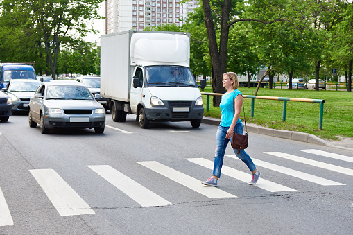 Mujer cruzando la calle, en el cruce de peatones photo