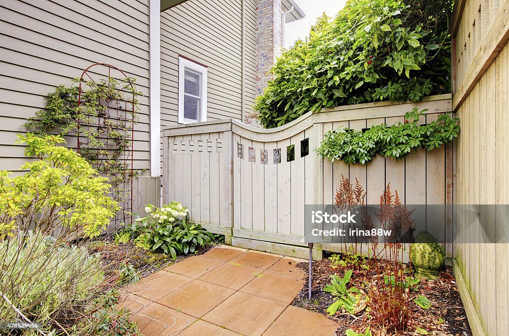 Gates and fence to the backyard Gates and fence to the backyard with side of the house Beige Stock Photo