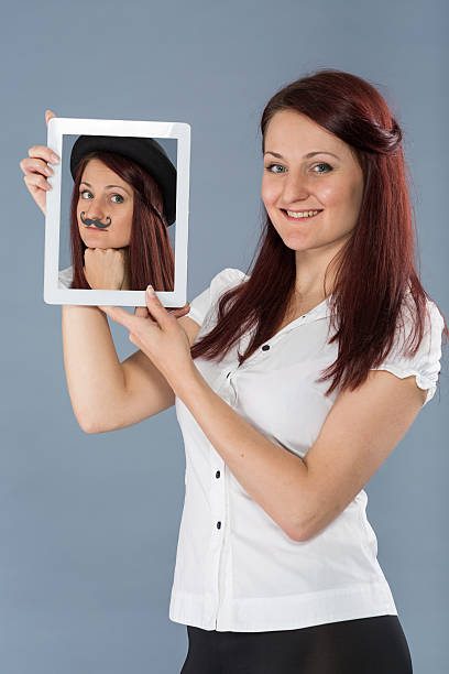 istock Red haired girl  holding tablet with her photo 478536324