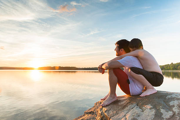 boy 包み、父親たちの夕暮れの湖の夏の - uncle ストックフォトと画像