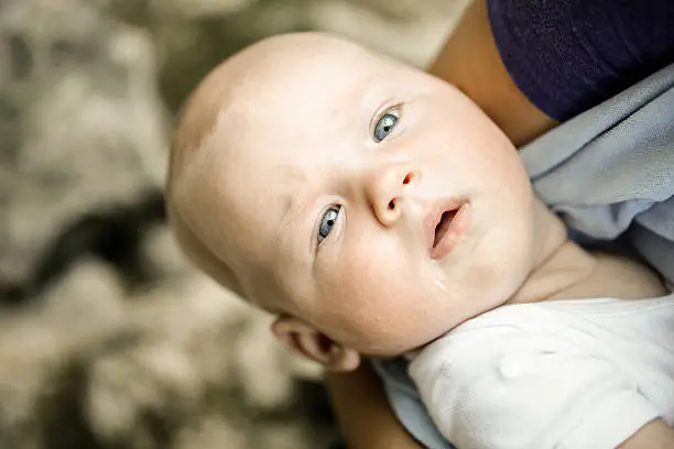 Photo of Well fed baby with blue eyes looking at camera