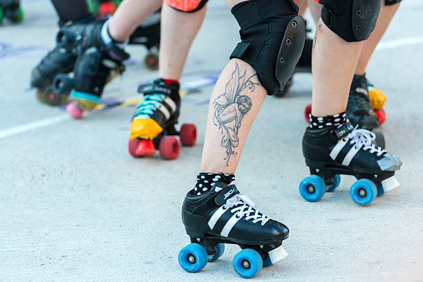 Female Roller derby competition in Madrid Madrid, Spain - June 20, 2015: Detail of the legs and roller skates of a group of young roller derby girls compete for the position during an exhibition show in La Cebada in Madrid. roller rink stock pictures, royalty-free photos & images