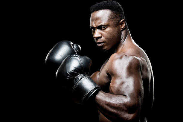 preto boxer macho posar com elevado fists - weight class imagens e fotografias de stock