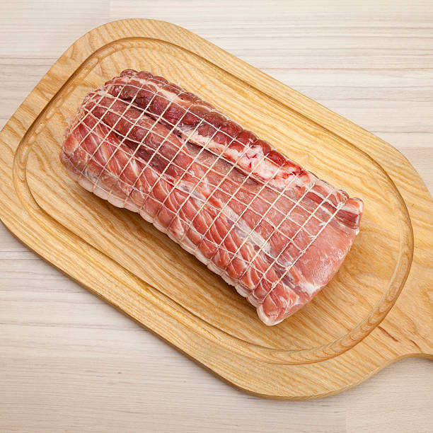 Raw rolled pork roast on chopping board