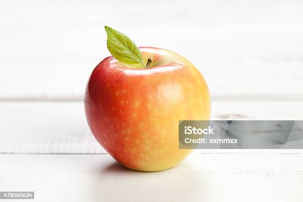 Colorful Apple With Leaf On White Table Stock Photo - Download Image Now - 2015, Apple - Fruit, Brightly Lit