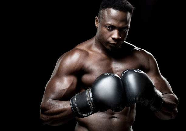 istock Black male boxer posing with raised fists 478560900