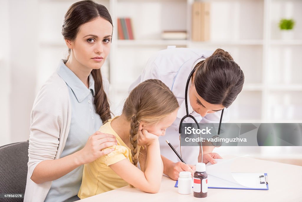 Pediartician Mother and her little daughter visiting doctor's office. 2015 Stock Photo