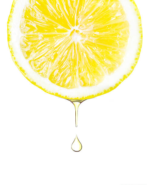Sliced lemon with juice dropping. Isolated on white stock photo