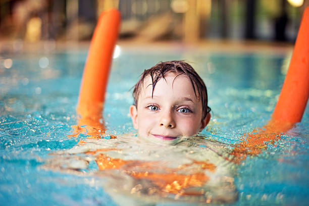 istock Little boy learning to swim with pool noodle 478562746