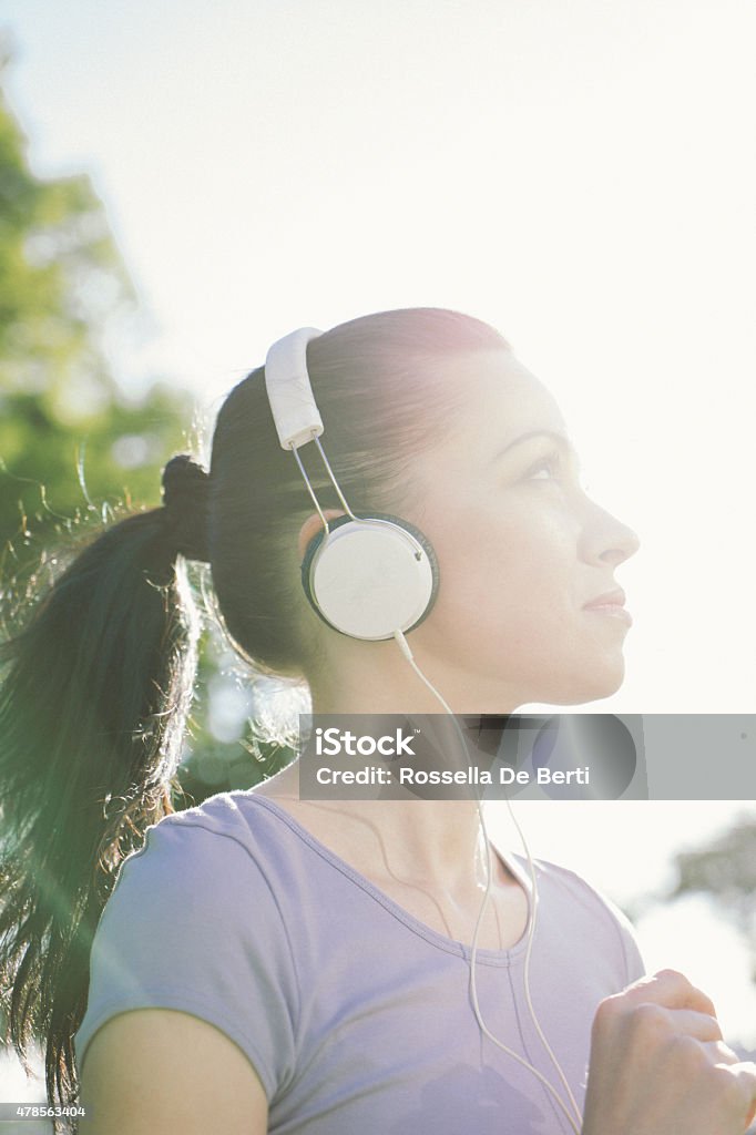 Beautiful Woman Running And Listening To Her Favorite Music Beautiful woman running in a city park listening her favorite music. 2015 Stock Photo