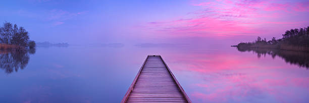 Jetty on a still lake at dawn in The Netherlands