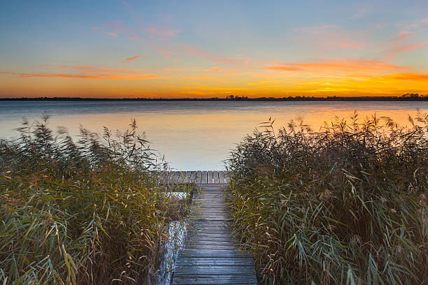 arancio tramonto sul molo sulla riva del lago - plank boardwalk pontoon bridge summer foto e immagini stock