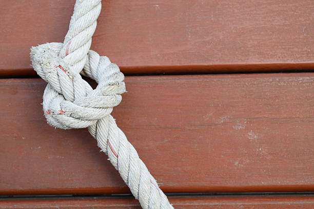 istock Rope knot on wooden floor background 478570850