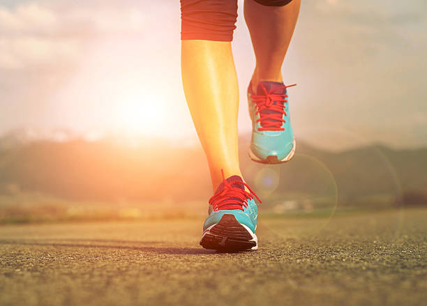 istock Runner athlete feet running on road under sunlight. 478571388