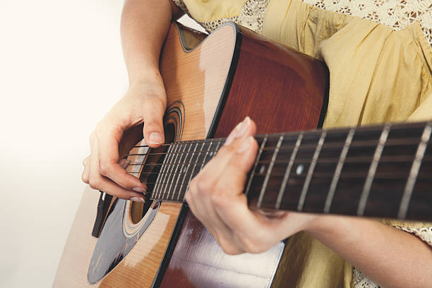 istock woman's hands playing guitar, close up. Vintage tone 478571786