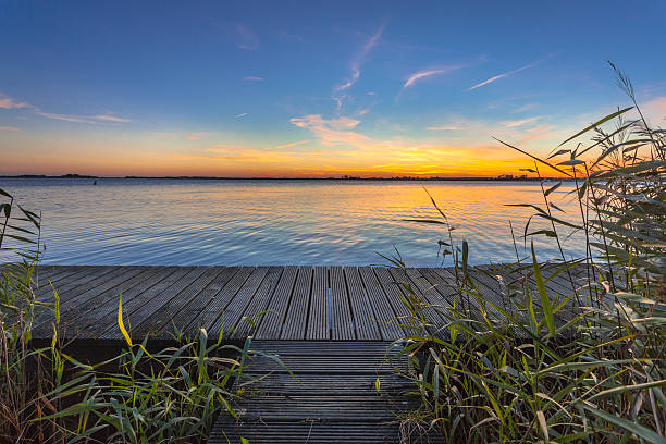 청색 및 주황색 석양을 에 보드워크의 호수 - boardwalk pontoon bridge landscape sky 뉴스 사진 이미지