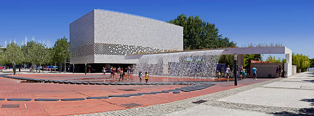 Waterfall of the Jardins De agua, the Parque das Nacoes Lisbon, Portugal - August 02, 2013: Visitors pass in front of the Waterfall of the Jardins Dagua (Water Gardens) and the entrance of the Oceanarium in the Parque das Nacoes (Park of Nations). oceanário de lisboa stock pictures, royalty-free photos & images