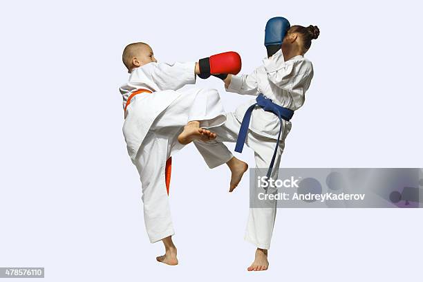 Girl And Boy In Karategi Exchanged Blows Legs Stock Photo - Download Image Now - 2015, Activity, Belt